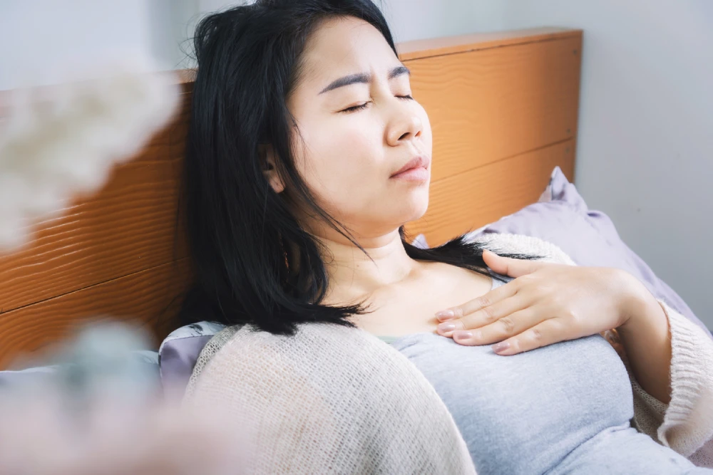 woman lying propped up to manage acid reflux symptoms