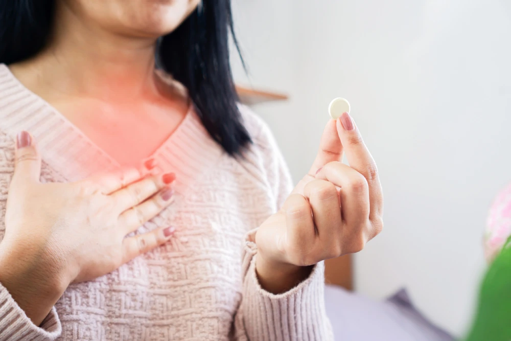 woman holding an antacid, a common acid reflux treatment option