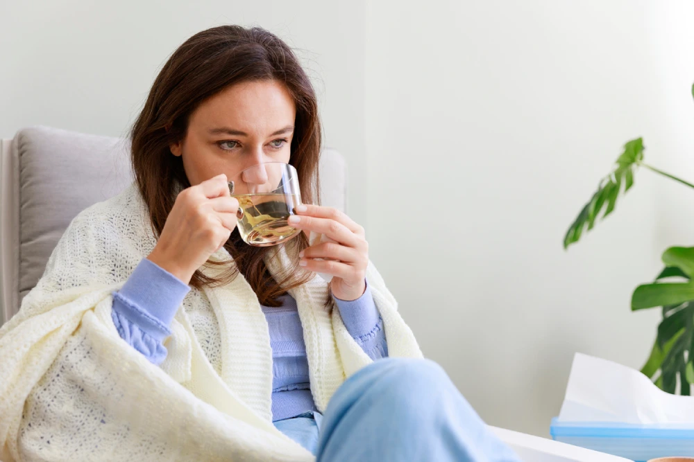 woman with the flu drinking tea