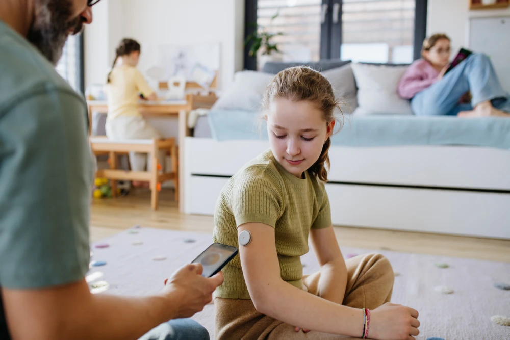 child with a wearable blood sugar level monitor for diabetes