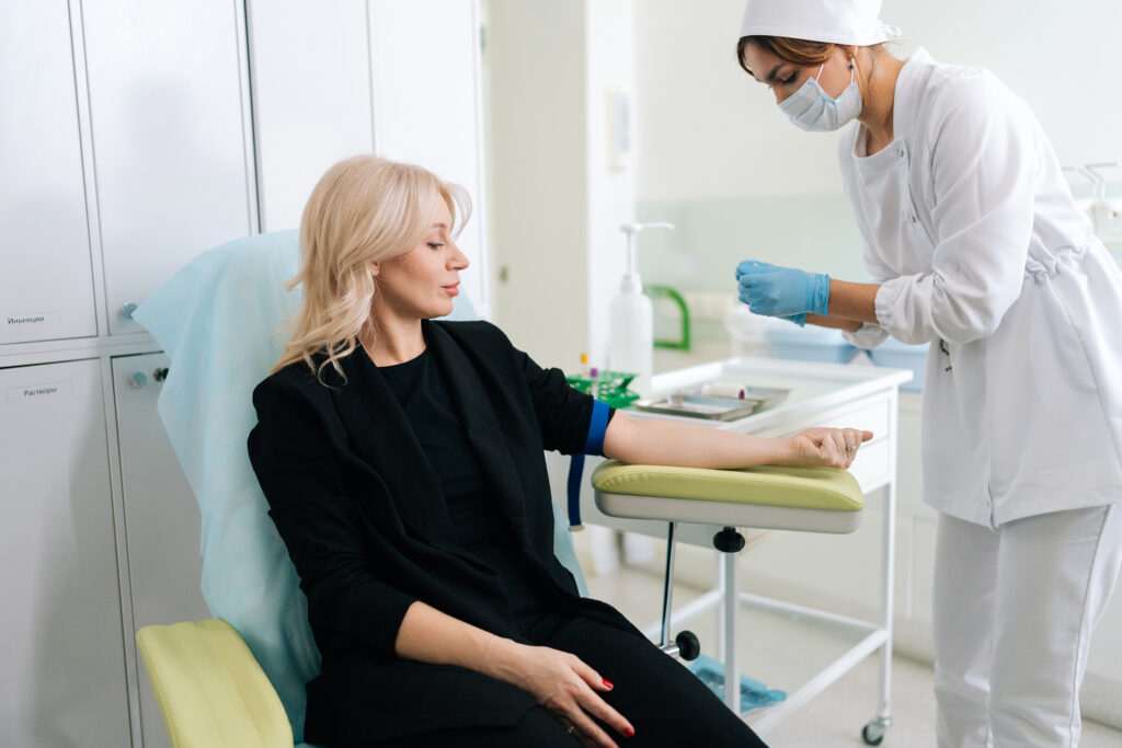 A nurse is doing bloodwork on a young female patient.