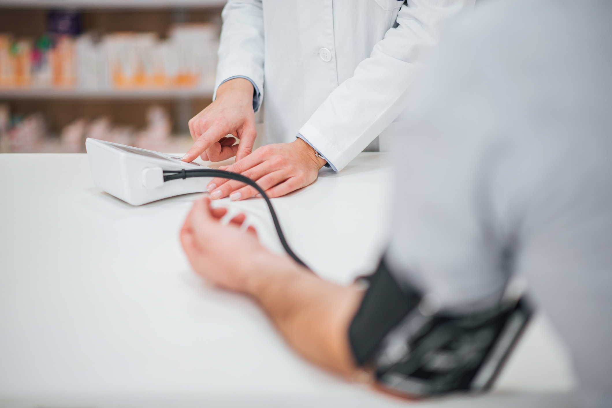 A pharmacist is measuring blood pressure of a male patient.
