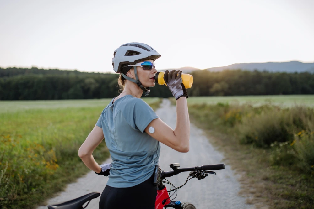 woman with diabetes glucose monitor biking - staying active for diabetes prevention 