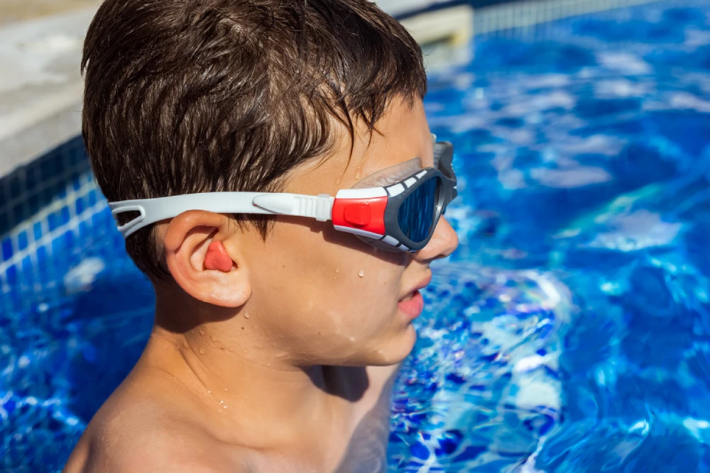 child wearing earplugs for swimming