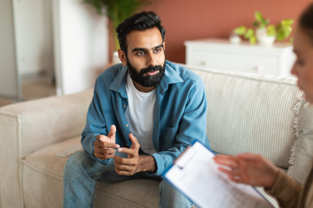 A young man sits with his therapist in her office.