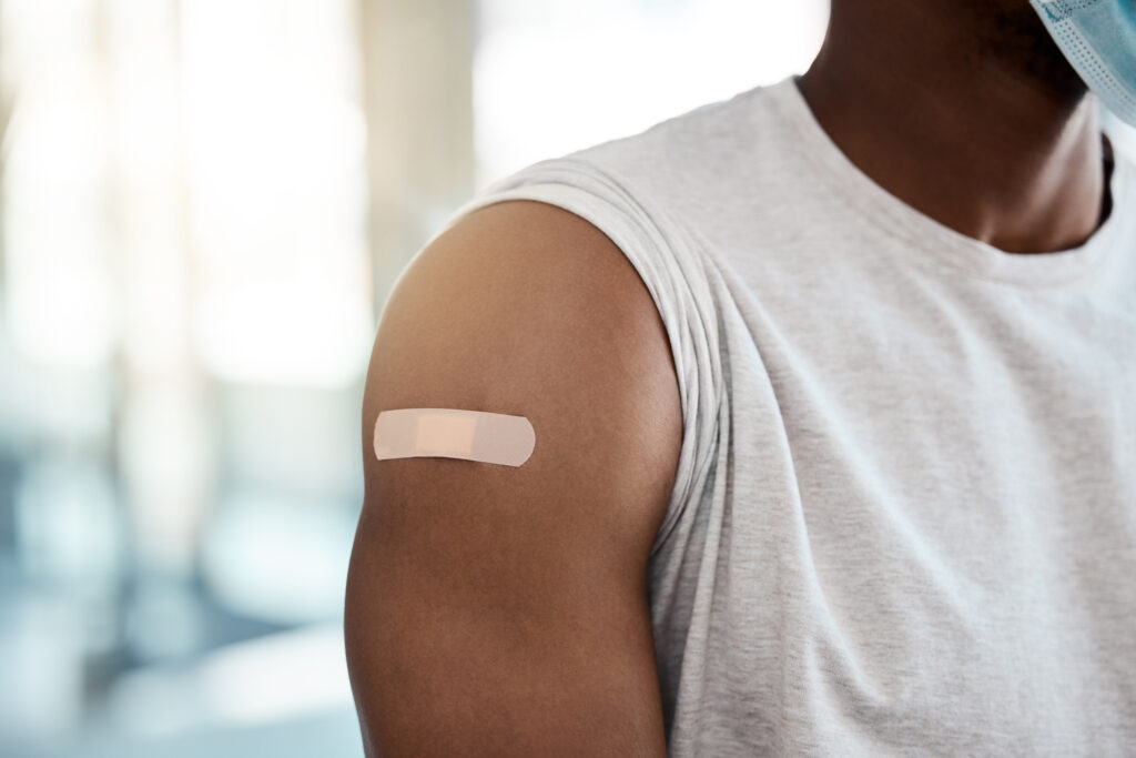 Un pansement recouvre la piqûre du vaccin contre la grippe sur le bras d'un homme.