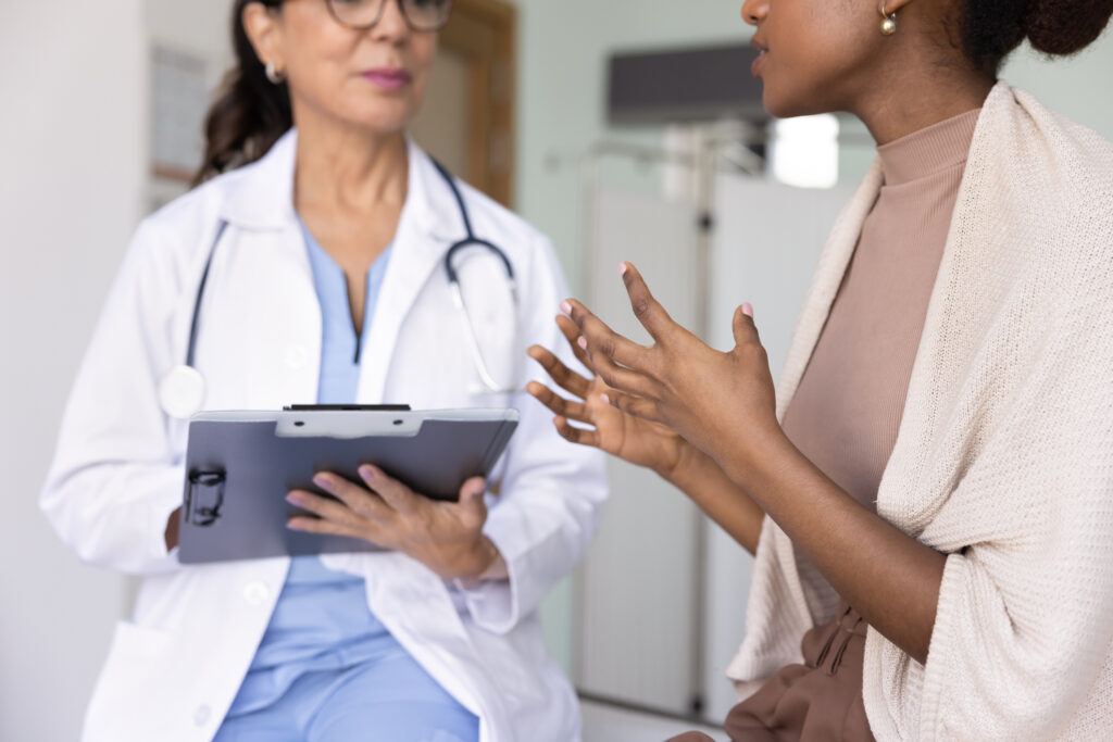 A young woman is having a serious conversation with her female doctor. 